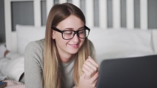 Primo piano di una donna freelance sdraiata sul letto e guardare un video di una passera nel suo timeout — Video Stock