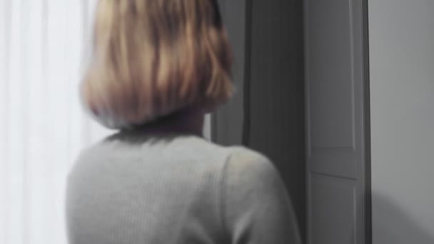 A nő kinyitja a hűtőszekrény ajtaját otthon a konyhában, és elviszi a tartályt étellel — Stock videók