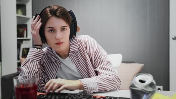 Unalmas nő játszik videojátékok a számítógépén, és eszik snack otthon — Stock videók