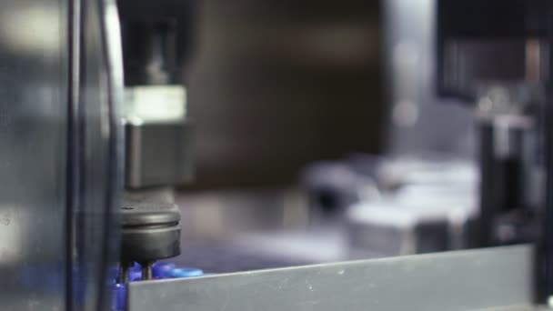 Роботизированная рука после производства устанавливает фармацевтические бутылки с прозрачной жидкостью. Автоматическое промышленное оборудование . — стоковое видео