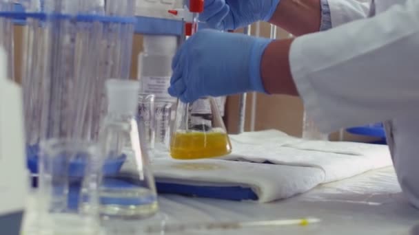 Científico investigador químico trabajando en el laboratorio con líquidos de colores — Vídeo de stock