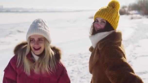 Två kvinnor vänner har kul i vinter park — Stockvideo