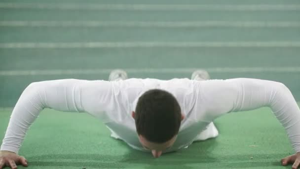 Jovem a fazer flexões no estádio verde. Close-up de desportista durante o treino matinal. Conceito de estilo de vida saudável — Vídeo de Stock