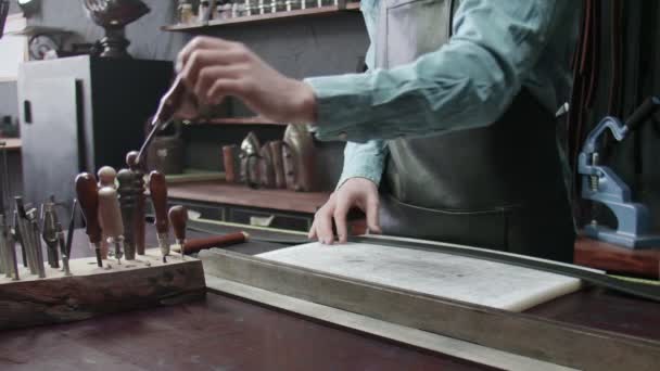 Garvaren plockar upp ett verktyg för att arbeta med läder. Många olika verktyg för handgjorda. Metallverktyg — Stockvideo