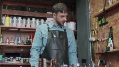 Erkek bronzlaştırıcı yeni kemer hakkında bir müşteriyle görüşmek için telefon kullanıyor.