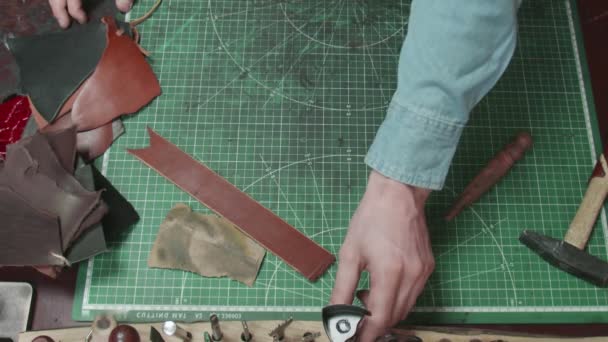 Närbild av lädersyprocessen. Händerna med nål och snören gör plånbok i verkstaden. Process för tillverkning av läder plånbok handgjorda. Handgjorda lädervaror i slow motion. — Stockvideo