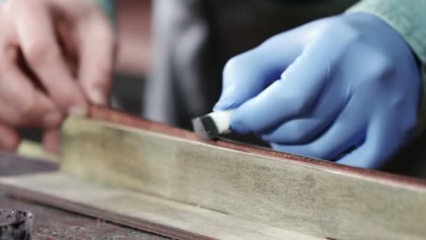 Aplicando tinte de borde negro al cuero. Proceso de trabajo del cinturón de cuero en el taller de cuero . — Vídeo de stock