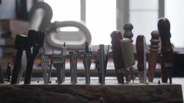 Herramientas curtidoras en soporte de madera. Proceso de trabajo en el taller de cuero . — Vídeo de stock