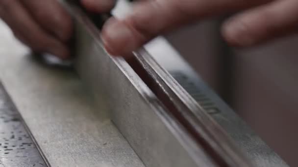 Nahaufnahme eines professionellen Gerbers, der in der Werkstatt einen Gürtel herstellt — Stockvideo