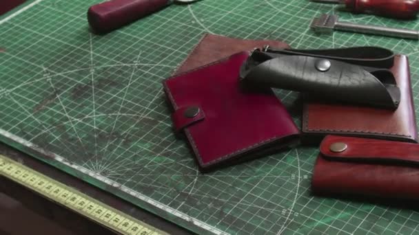 Färdiga handgjorda läderplånböcker nyckelhållare på garvare bord — Stockvideo