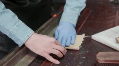 Profesyonel bir tabakçı kemer için bez kullanır. Deri atölyedeki deri kemerin çalışma süreci..