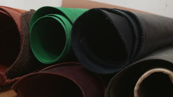 Rollos de cuero de diferentes colores. Proceso de trabajo en el taller de cuero . — Vídeo de stock