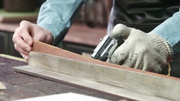 Een lederen meester is stervende lederen riemranden met vuur. Werkproces van de lederen band in de leerwerkplaats. — Stockvideo