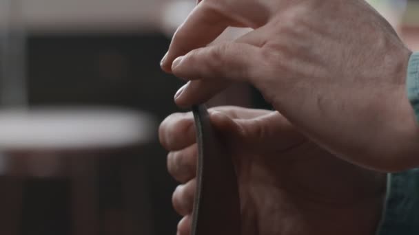 Gros plan de tanneur professionnel met de la pâte sur une ceinture en atelier. Processus de travail de la ceinture en cuir dans l'atelier de cuir . — Video