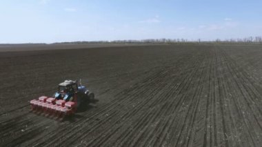 Tarımsal traktör ekiyor ve ekiyor.