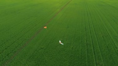 Çiftçi tarlalarını kontrol eden profesyonel İHA uçağı yerde yatıyor.