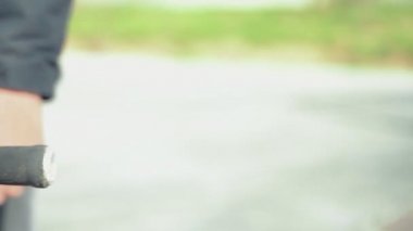 Tanımlanamayan ekstrem bmx motorcusu elinde bisikletle duruyor ve elini kol parmaklıklarına koyuyor.