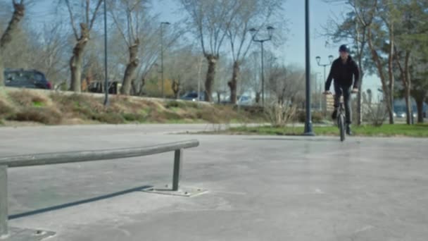 Młody jeździec robi sztuczki na rurze w skate parku. — Wideo stockowe