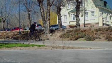 Genç bir bmx binicisi kaykay parkında boruların üzerinden döner..