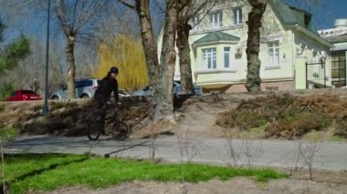 Genç bir bmx binicisi kaykay parkında boruların üzerinden döner..