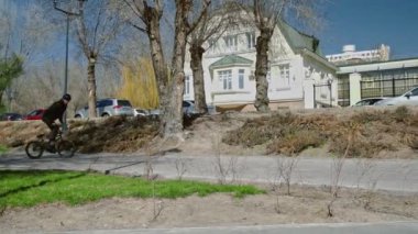 Genç bir bmx binicisi kaykay parkında boruların üzerinden döner..