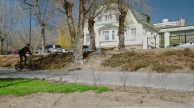 Genç bir bmx binicisi kaykay parkında boruların üzerinden döner..