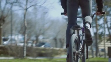 Genç bir BMX binicisi rampaya biner ve paten sahasında eski numaralar yapar.
