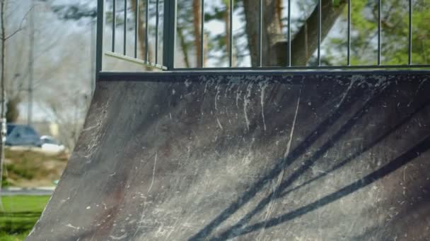 Um jovem cavaleiro bmx montando em rampas e realizando truques no parque de skate — Vídeo de Stock