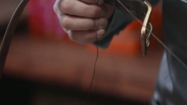 Yakından bakınca, deri atölyesinde kahverengi deri kemer yapan bir adam var. Deri atölyedeki deri kemerin çalışma süreci..