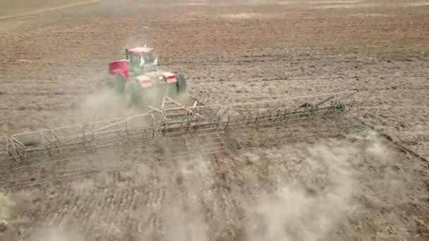 Luchtfoto van landbouwtrekkers die ploegen en sproeien op het veld — Stockvideo