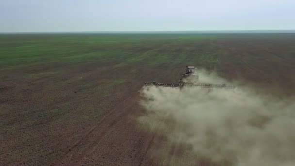 Vue aérienne d'un agriculteur en tracteur préparant des terres agricoles. Vue du haut vers le bas champs de labour tracteur blanc, préparer la terre pour l'ensemencement .