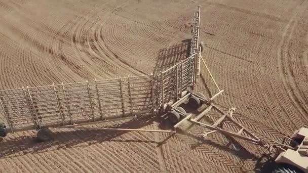 Flygfoto av en kraftfull energimättad traktor med en stor krokkraft, utför jordbearbetning för sådd av vintergrödor med en tallrikskultivator på hösten — Stockvideo