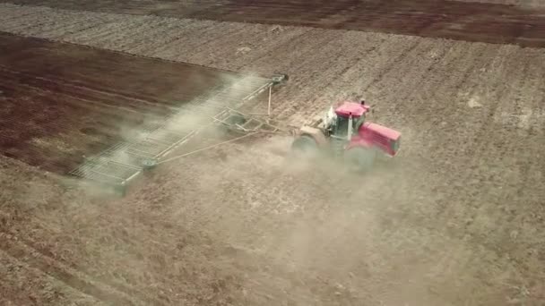 Vista aérea de un potente tractor saturado de energía con una gran fuerza de gancho, que realiza labranza para sembrar cultivos de invierno con un cultivador de discos en otoño — Vídeo de stock
