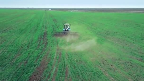 Vedere aeriană a aratului și pulverizării tractorului agricol pe teren — Videoclip de stoc