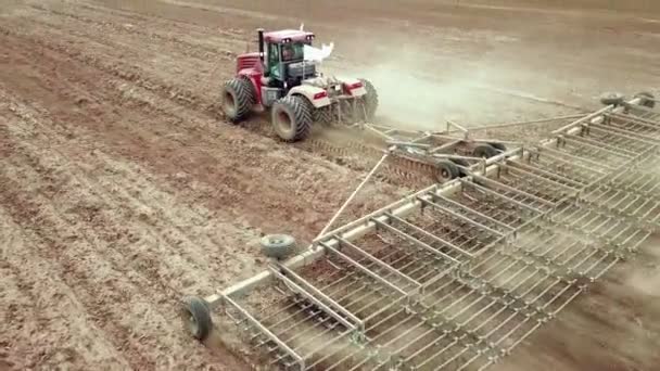 Vista aérea del tractor agrícola arando y pulverizando en el campo — Vídeos de Stock