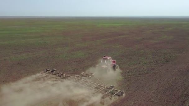 Vue aérienne d'un agriculteur en tracteur préparant des terres agricoles. Vue du haut vers le bas champs de labour tracteur blanc, préparer la terre pour l'ensemencement .