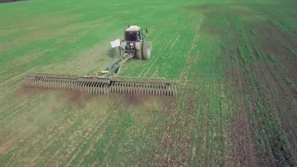 Luftaufnahme eines leistungsstarken, energiegesättigten Traktors mit großer Hakenkraft, der im Herbst mit einem Scheibenmulchgerät die Bodenbearbeitung für die Aussaat von Wintergetreide durchführt — Stockvideo