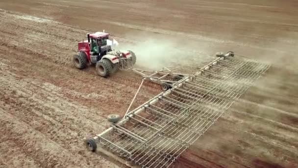 Vista aérea de un agricultor en tractor preparando tierras en tierras de cultivo. Vista superior hacia abajo tractor blanco arar campos, preparando la tierra para la siembra . — Vídeo de stock