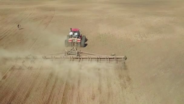 Vue aérienne d'un puissant tracteur saturé d'énergie avec une grande force de crochet, effectuant du travail du sol pour semer des cultures d'hiver avec un cultivateur à disques à l'automne 