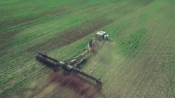 Fermier dans un tracteur avec un semoir prépare la terre pour semer des cultures céréalières dans le champ labouré. Planter des graines dans la poussière. Travaux agricoles de printemps. Vue aérienne du dessus, drone voler vers l'avant suivre tracteur 