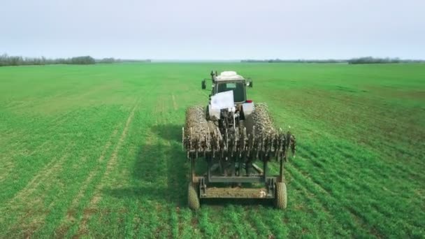 Boer in een trekker met zaaimachine bereidt het land voor het zaaien van graangewassen in ploegveld. Zaden planten in stofgrond. Landbouwwerkzaamheden in het voorjaar. Bovenaanzicht vanuit de lucht, drone fly forward volg trekker — Stockvideo