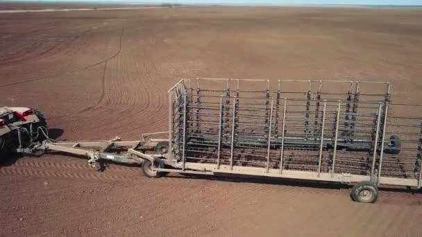 Drohne fliegt im Kreis um Fermers Traktor auf dem Feld — Stockvideo