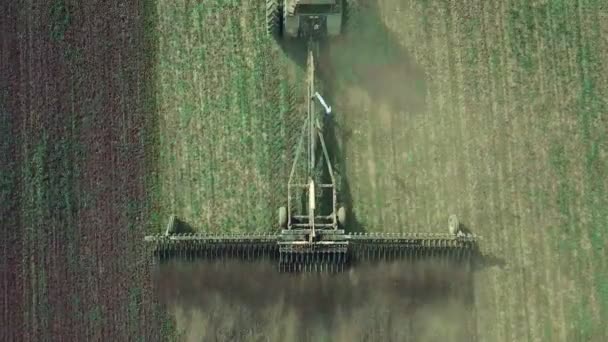 Vista aérea de um poderoso trator saturado de energia com uma grande força de gancho, realizando lavoura para semear culturas de inverno com um cultivador de discos no outono — Vídeo de Stock