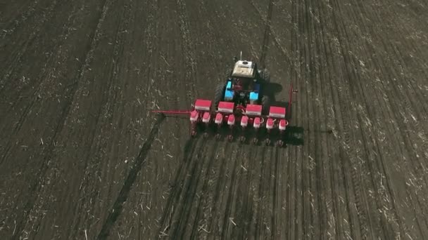 Traktor med speciella precisionssåmaskiner, frösådd arbetar i fält, jordbruksmaskiner planterar majs eller solrosfrön i nyplöjd mark. — Stockvideo