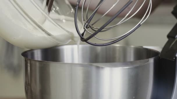 Electric mixer being used to mix cream and dough — Stock Video