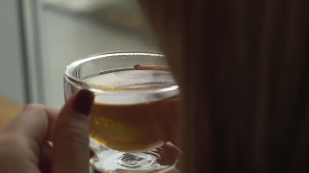 Hermosa joven disfrutando del té. Mujer soplando en un té caliente — Vídeos de Stock