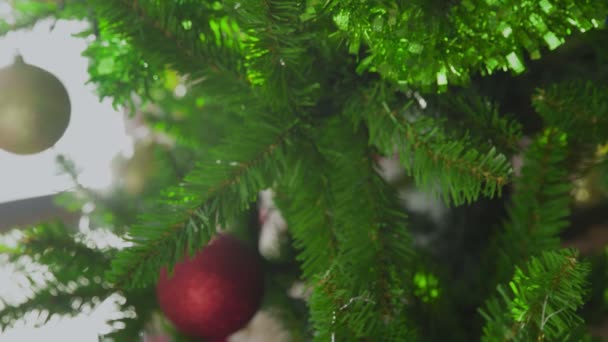 Vrouwen handen versieren op kerstboom met gele bal. — Stockvideo