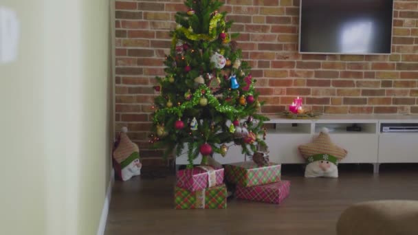 Όμορφη γυναίκα βάζοντας δώρο κάτω από το χριστουγεννιάτικο δέντρο σε πολυτελές σπίτι — Αρχείο Βίντεο