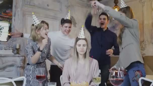 Fille d'anniversaire triste est assis à la table tandis que des amis la félicitent — Video