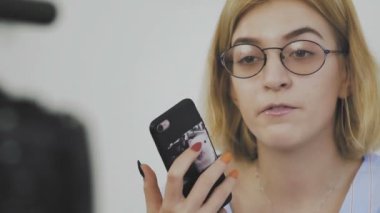 Genç ve güzel bir kadın profesyonel güzellik blogcusu veya blog yazarı video kaydediyor ve abonelerin sorularını yanıtlıyor